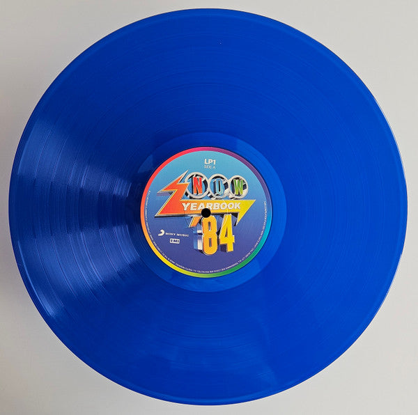 Image of Label Cover of 3xLP - VG/VG+ - VARIOUS, Now Yearbook '84 (Sony Music; LPYBNOW84, UK 2021, Black Inners, Blue Vinyl), Creasing, indents on sleeve, small stain on front, faint ring wear., - 3446125S