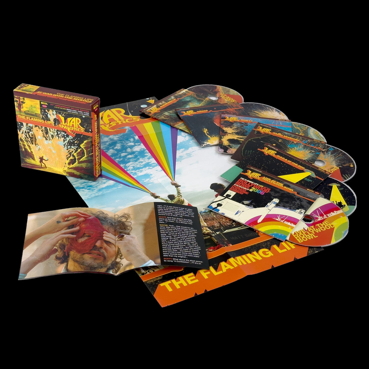 Image of Front Cover of 6xCD - NEW - THE FLAMING LIPS, At War With The Mystics (Rhino Warner; , UK 2026 Reissue, Box Set, 6CD Anniversary Box), , 20th anniversary expanded edition of the 2006 Flaming Lips album, featuring the first remaster of the original album, previously unreleased demos and studio recordings, and additional non-album material. The 6CD set features the original album remastered for the very first time, 19x previously unreleased Demos, 14x previously unreleased studio recordings, a furthe