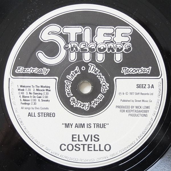 Image of Label Cover of LP - VG/VG+ - ELVIS COSTELLO, My Aim Is True (Stiff; SEEZ 3, UK 1977, Non-Laminated, Yellow Back Cover), Mild fading along spine. ,  - 2426228E