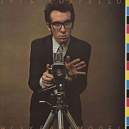 Image of Front Cover of 0125279E: LP - ELVIS COSTELLO, This Year's Model (Radar Records; RAD 3, UK 1978, Offset Sleeve, Inner, No 7". "ASK MOIRA FOR YOUR  PRIZE" Runout.) Sticker Residue on Sleeve  VG/VG