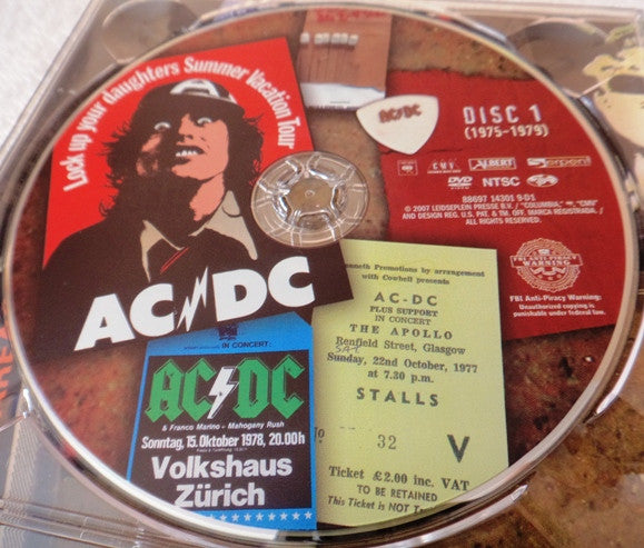 Image of Label Cover of 4434021E: 3xDVD - AC/DC, Plug Me In (Columbia; 88697 14301 9, US 2007, Outer Card Sleeve, Box Set, Poster, Memorabilia, New Liner Notes and Unseen Photos.) A few light marks on discs. Light wear to O-Card.  VG/VG