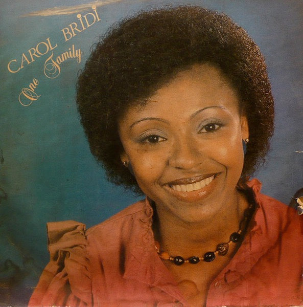 Image of Front Cover of 4714308C: LP - CAROL BRIDI, One Family (Otto Records; OTL 001, Nigeria 1984, Laminated Sleeve, Signed Sleeve) Faded signature by Carol Bridi to front and back sleeve. Sleeve is intact but has some spine/corner wear + laminate creasing. Disc has lots of hairlines and scuffs, plays through with some surface noise. Slightly dished.  VG/G