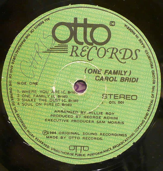 Image of Back Cover of 4714308C: LP - CAROL BRIDI, One Family (Otto Records; OTL 001, Nigeria 1984, Laminated Sleeve, Signed Sleeve) Faded signature by Carol Bridi to front and back sleeve. Sleeve is intact but has some spine/corner wear + laminate creasing. Disc has lots of hairlines and scuffs, plays through with some surface noise. Slightly dished.  VG/G