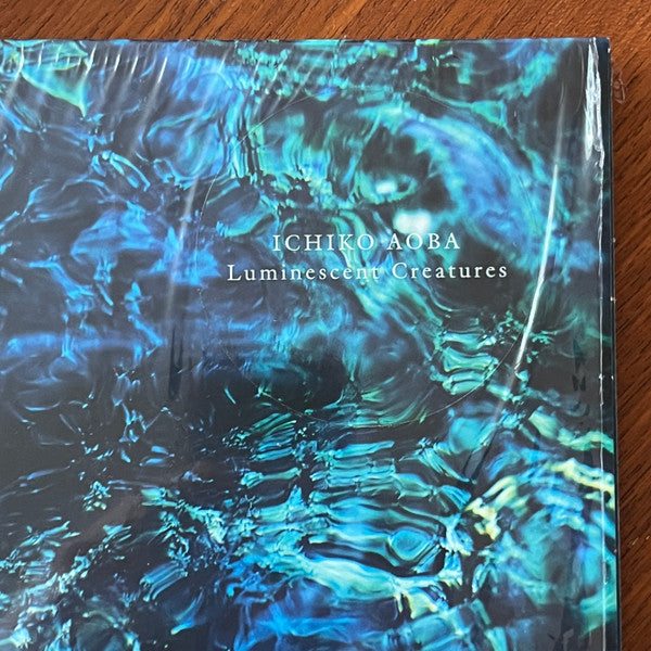 Image of Back Cover of LP - NEW/NEW - ICHIKO AOBA, Luminescent Creatures (Hermine; HERM003LP, Europe 2025, Poster), , To listen to Ichiko Aoba is to be drawn into a world as intimate as a warmly lit home, but cosmic in scale. The Japanese singer, songwriter, composer, and multi-instrumentalist, has taken a dedicated online fanbase built from TikTok sounds and critically acclaimed, and translated that into international tours spanning more than 20 countries. She was well known in Japan collaborating with art