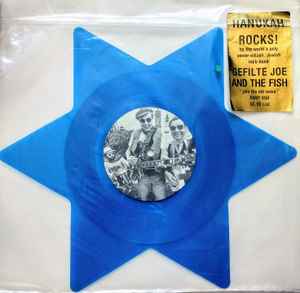 Image of Front Cover of 0126004E: 12" - GEFILTE JOE AND THE FISH, Hanukah Rocks (Rhino Records; RNEP 650, US 1981, Clear Plastic Stickered Sleeve, Translucent blue vinyl star shaped picture disc.)   VG/G+