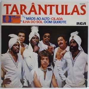 Image of Back Cover of 7" - VG/G+ - TAR NTULAS, M os Ao Alto / Cilada / Ilha Do Sol / Dom Quixote (RCA; 102.0335, Brazil 1982, Picture sleeve), Light marks. Ringwear & sticker on sleeve., A1 - M os Ao Alto (Hands Up) (Give Me Your Heart)A2 - CiladaB1 - Ilha Do SolB2 - Dom Quixote (Don Quijote) - 1926133E