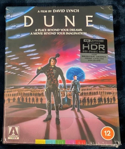 Image of Front Cover of 3xBlu-Ray - EX/M - DAVID LYNCH, Dune (Arrow Video; FCD2186, UK 2021 Reissue, Steelbook In Slipcase, 2 Books, Poster & Postcards, 4K UHD HDR), Still SEALED in stickered shrinkwrap. Shrinkwrap slightly split.,  - 2116359C