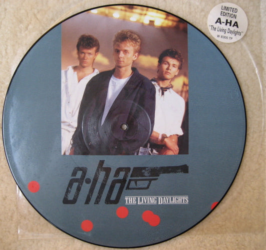 Image of Front Cover of 12" - VG/G+ - A-HA, The Living Daylights (Warner Bros. Records; W 8305 TP, UK 1987, Plastic sleeve, Picture disc), Hype sticker on original plastic sleeve. Light marks on record but picture intact ,  - 2226386E
