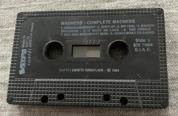 Image of Label Cover of Cassette - VG+/VG+ - MADNESS, Complete Madness (Stiff Records; STK/71004, Italy 1984 Reissue), Insert has white spine.,  - 2716252C