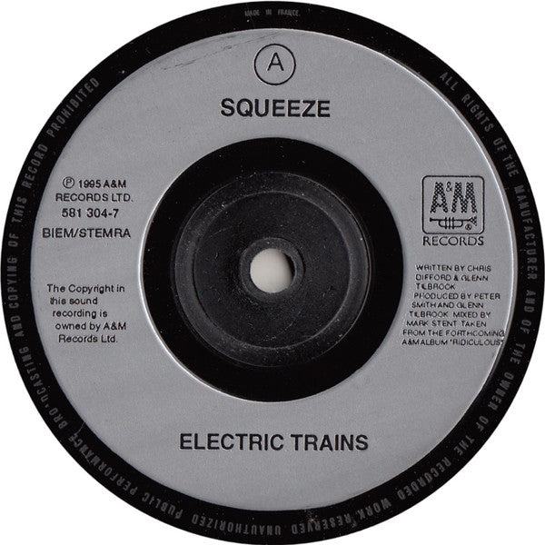 Image of Label Cover of 7" - VG+/VG+ - SQUEEZE, Electric Trains (A&M Records; 581 304-7, UK 1995, Barcode Stickered Plain Black Sleeve), Small promo stickers on label and sleeve, light crease to top.,  - 3016281C