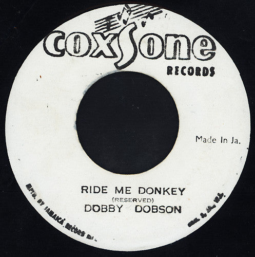Image of Front Cover of 7" - /G+ - DOBBY DOBSON, Ride Me Donkey (Coxsone Records; none, Jamaica ), Mark at start of A-side clicks lightly for a few rotations. Some light background noise throughout. Writing in marker pen and liquid staining all over labels,  - 3116298C