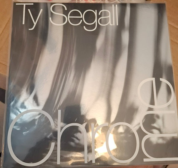 Image of Front Cover of LP - NEW/NEW - TY SEGALL, Chrome (Drag City; DC980, UK 2026, Inner), , Ty Segall, precleared for flight in full rock congress with the band (Ben Boye/Evan Burrows/Mikal Cronin/Emmett Kelly), shifts Chrome. Songs of massive riffs, swung, tightly arrayed lines of fuzz & distortion, twin-guitar attack-and-parry, endopic keyboards kicking, precise & thudding power, a rhythmic core on the march in full BAND energy. The songs are lyrically allusive trips, dark passages in the labyrinth, ev
