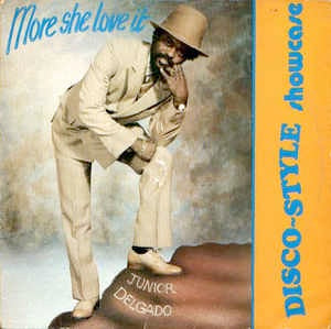 Image of Front Cover of 0116533C: LP - JUNIOR DELGADO, More She Love It Showcase (Yvonne's Special; YS001, UK 1981, Blue Vinyl) Lots of marks and scuffs on disc. Sleeve worn and frayed at edges.   G+/G+